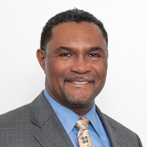 headshot of Tony Kinslow smiling and wearing a suit and tie