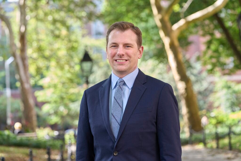 photo of Jonathan wearing a suit and tie with trees in the background