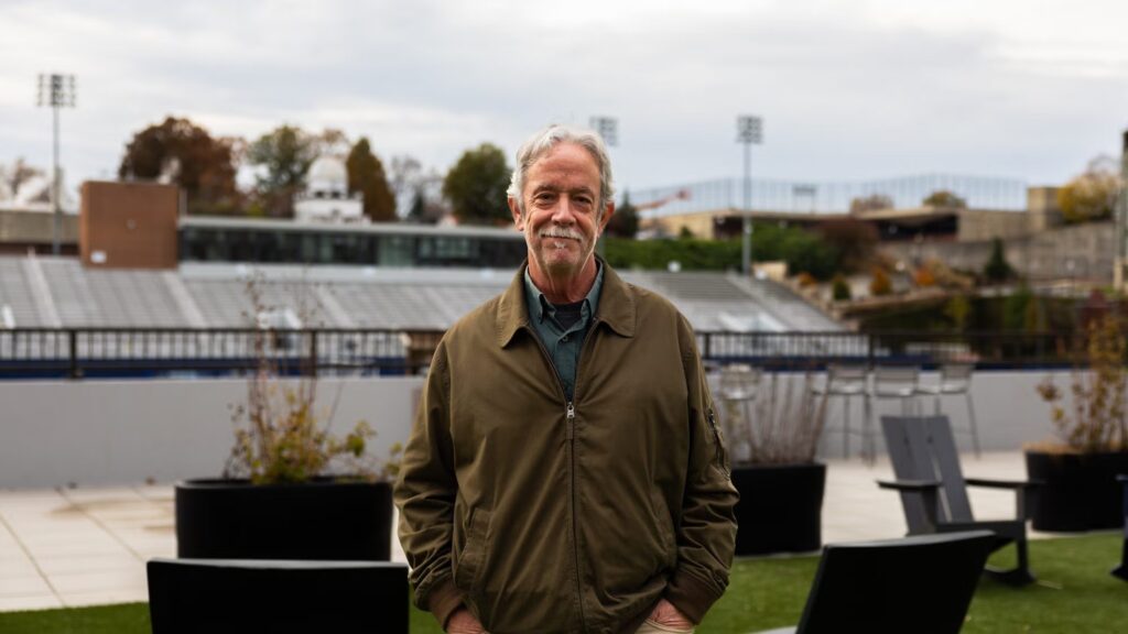 photo of Tom smiling against the backdrop of Cooper Field